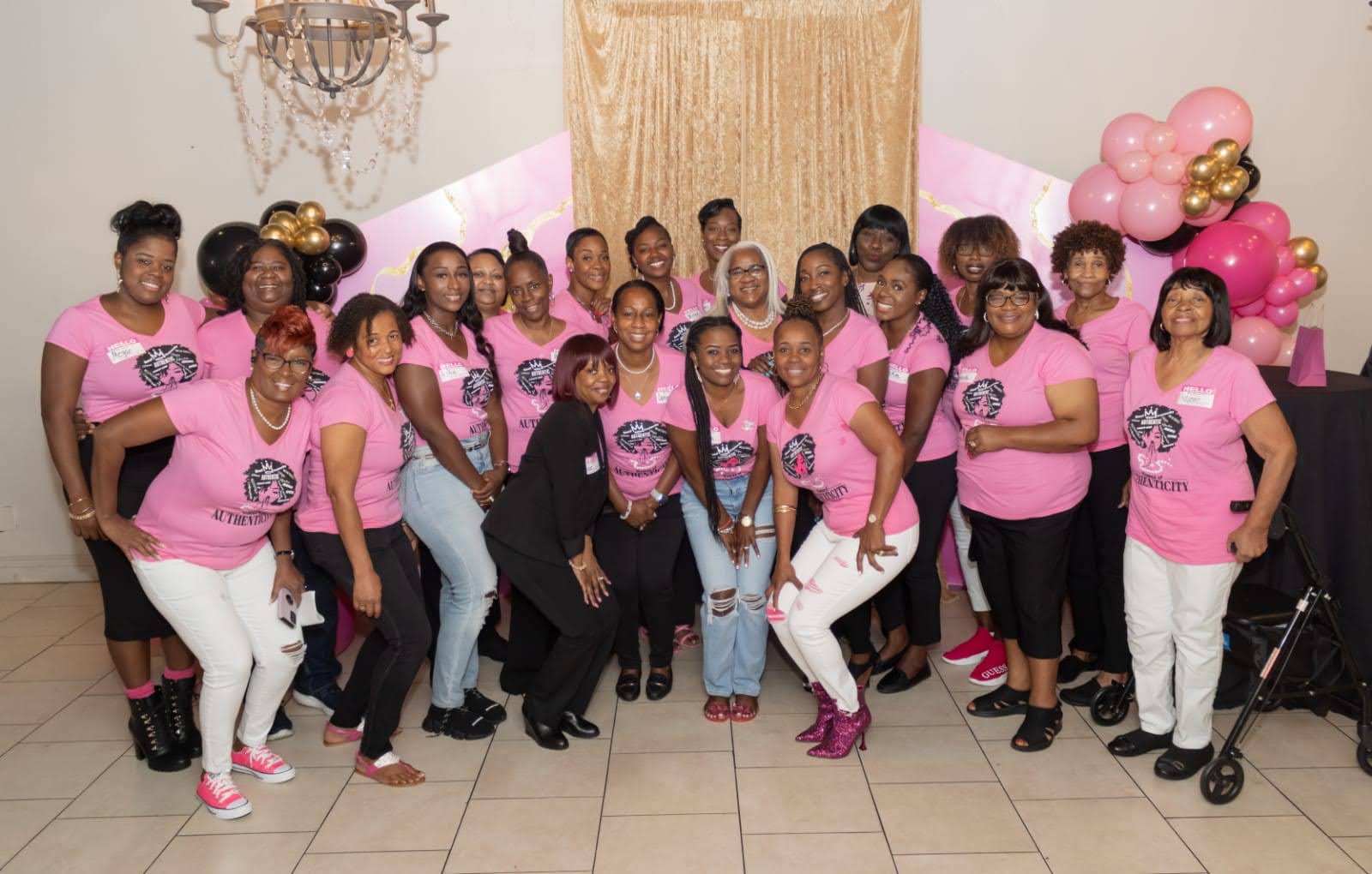 A group of women in pink shirts posing for the camera.